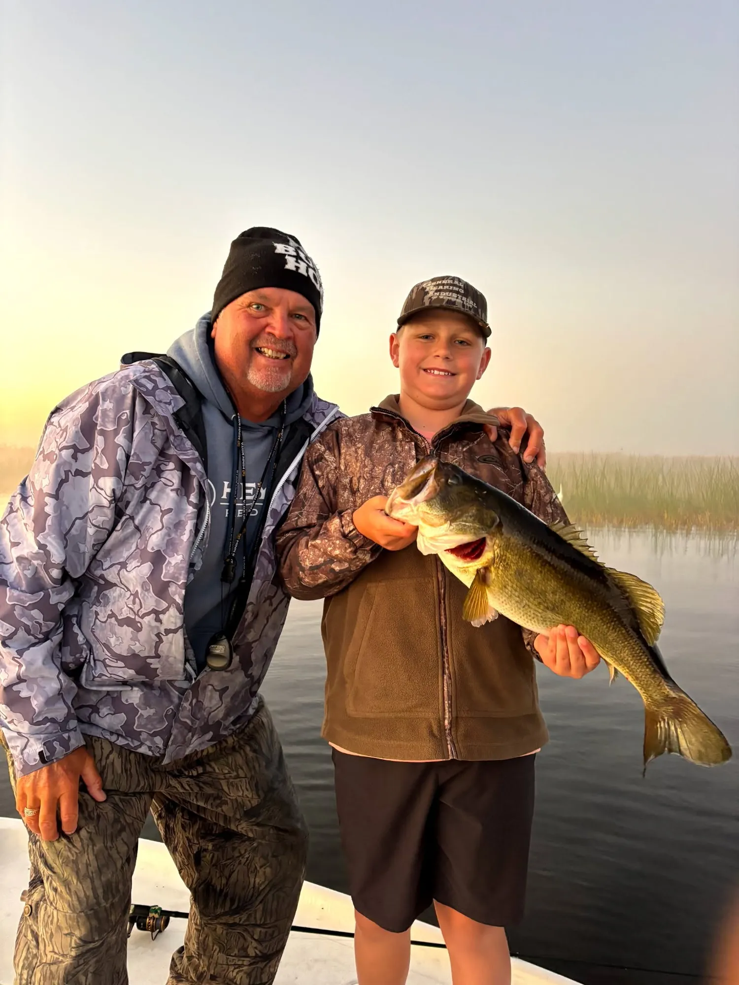 Capt. Bo White with a young angler holding a Lake Okeechobee largemouth bass at sunrise